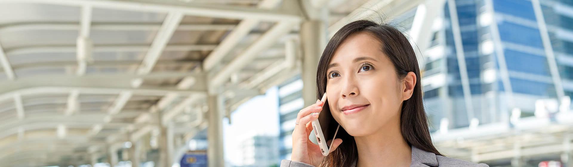 a businesswoman stands in a terminal on smart phone. 